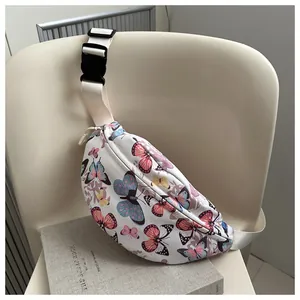 Dettaglio della tracolla in nylon bianco regolabile e della fibbia nera sulla borsa a farfalle