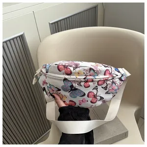 Dettaglio della borsa a tracolla in tela bianca con stampe di farfalle colorate e zip in metallo