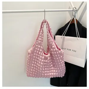 Detail of pink puffy bubble shoulder bag with pleated texture on a white hanger