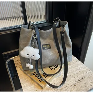 Détail du cabas en toile grise avec anses noires et pendentif nuage en peluche doux