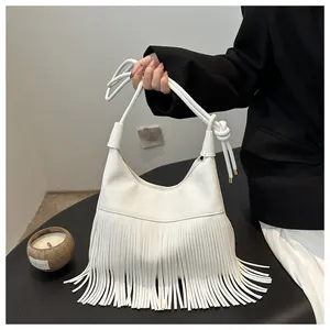 Detalle del bolso hobo blanco con grabado de lichi, flecos largos y correa anudada