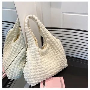 Detailed macro view of cream-white bubble texture fabric on a stylish tote bag