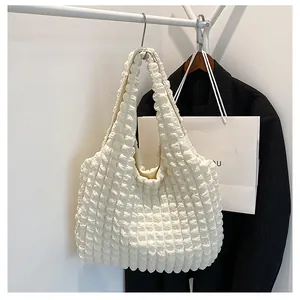 Detail of creamy white tote bag featuring bubble texture and soft popcorn fabric