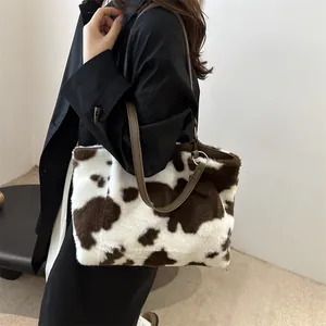 Dettaglio della borsa tote in peluche maculata con manici in pelle marrone e anelli