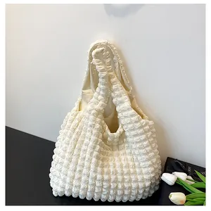 Detail of cream popcorn texture fabric on a large capacity summer tote shoulder bag