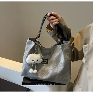 Vue détaillée du sac cabas en toile grise avec sangle noire et breloque nuage
