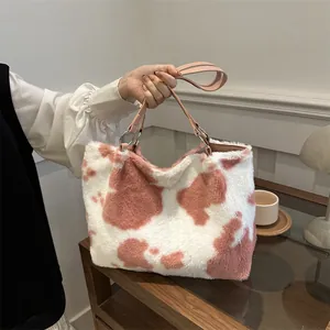Dettaglio della borsa tote in ecopelliccia con stampa mucca rosa e manico in pelle