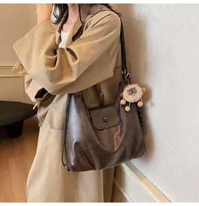 Detail of vintage dark brown faux leather tote bag with cute sheep charm accessory