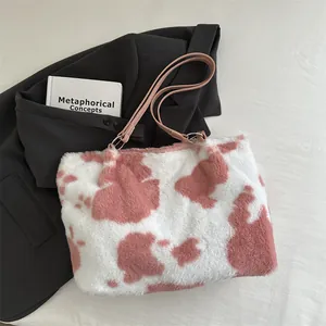 Dettaglio della borsa tote in peluche rosa con motivo mucca e spalline in pelle