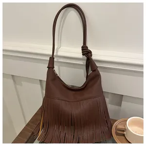 Detalle del bolso hobo de cuero marrón oscuro con flecos y acabado de grano de lichi