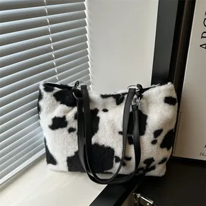 Vista dettagliata della borsa tote in peluche zebrata con manici neri in pelle e anelli