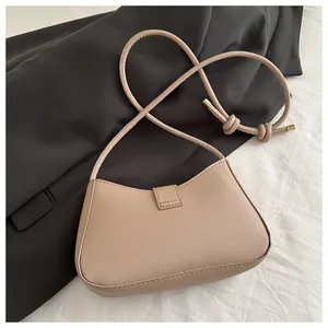 Vue de dessus du sac croissant beige avec texture de cuir fin et embouts dorés chic