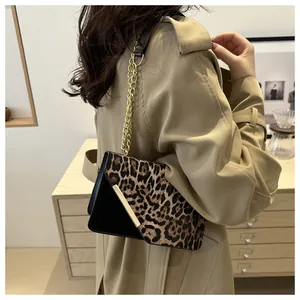Dettaglio borsa a spalla leopardata con catena dorata e finiture in metallo lucido