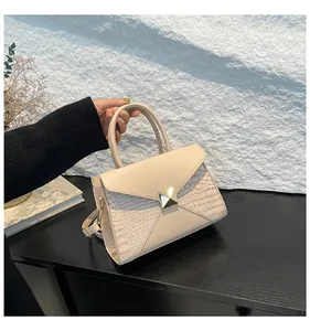 Détail du sac à main en cuir thé au lait avec fermoir doré et texture effet crocodile