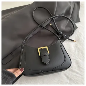 Détail du sac croissant noir avec boucle carrée dorée et bandoulière en corde nouée