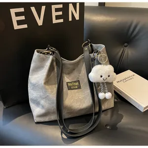 Détail du sac cabas gris foncé avec anneaux dorés et breloque nuage en peluche