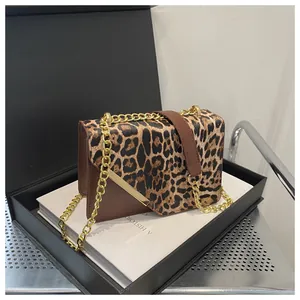 Dettaglio borsa squadrata leopardata con catena dorata in una confezione regalo