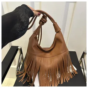 Detalle de un bolso de hombro en cuero marrón con flecos largos de estilo bohemio