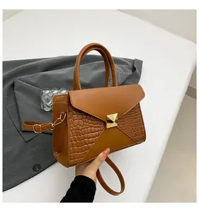 Détail du sac carré marron caramel avec relief crocodile, fermoir doré et poignée supérieure