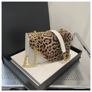 Dettaglio della patta leopardata con bordo dorato e tracolla a catena della borsa a tracolla