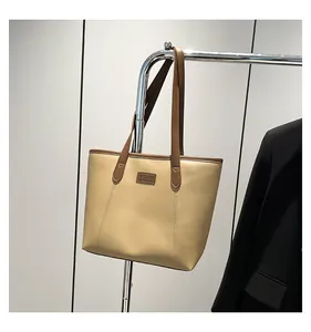 Detail view of the beige and brown tote bag showing the fine PU leather texture and strap
