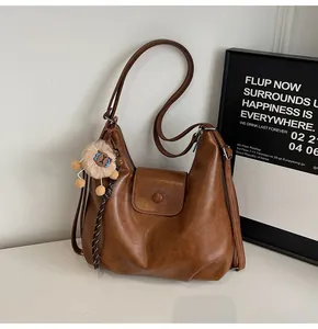 Macro shot of brown PU leather tote bag texture with cute plush lion keychain decoration