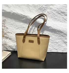 Close-up of beige and brown leather tote bag detail with the FASHION label on the front