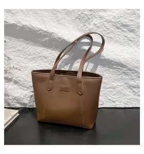 Detailed close-up of dark brown matte PU leather tote bag with FASHION label