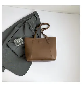 Detail of coffee brown PU leather tote with Fashion patch and elegant stitching