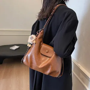 Brown vintage large tote bag with leather texture and plush lion pendant detail