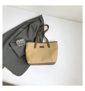 Close-up of beige and brown tote bag with fashion label on white background