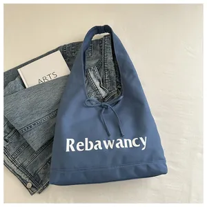 Detail of blue canvas tote bag with Rebawancy lettering and decorative bow tie