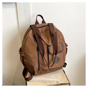 Detail view of large brown versatile backpack with multi-pocket design and nylon texture