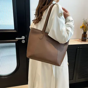 Brown leather tote bag for women with fashion label shown from a side perspective