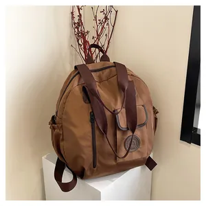 Detailed close-up of brown waterproof nylon backpack with side pockets and top handles