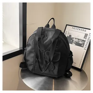 Detail of black multipurpose travel backpack featuring matte nylon texture and front flap pocket