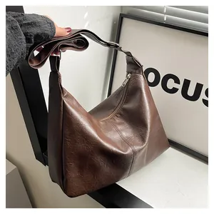 Detail view of the brown matte faux leather texture and silver zipper on the tote bag