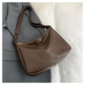 Close-up of dark brown tote bag with wrinkled leather texture and silver buckle