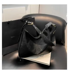 Detailed macro view of the black retro pleated leather texture and silver zipper of the tote