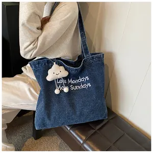 Deep blue denim tote bag with Less Mondays More Sundays embroidery and plush cloud charm