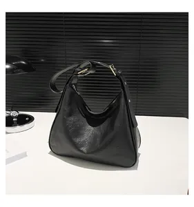 Detail of the black grainy leather hobo bag with gold adjustable buckle and zipper
