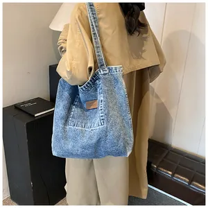Macro view of vintage acid wash denim tote bag showing detailed texture and leather patch