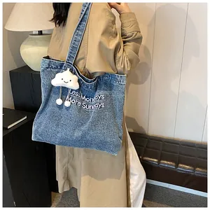 Detail of blue denim tote bag with Less Mondays More Sundays embroidery and cloud charm