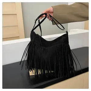 Dettaglio borsa tote in pelle scamosciata nera con lunghe frange e dettagli dorati