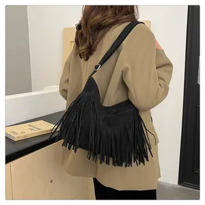 Dettaglio della borsa nera con nappe in scamosciato dal design boho a mezza luna