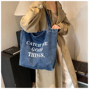 Detail of vintage navy denim tote bag with white CATCH THE GOOD THINGS slogan