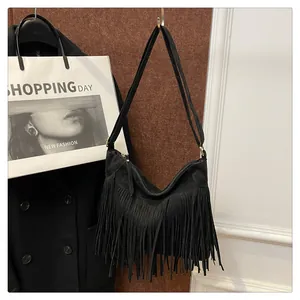 Dettaglio delle frange nere e della trama scamosciata su una borsa a tracolla trendy