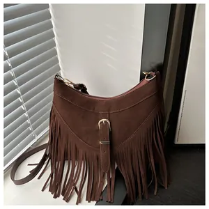 Dettaglio della borsa tote in pelle scamosciata marrone scuro con lunghe frange e fibbia