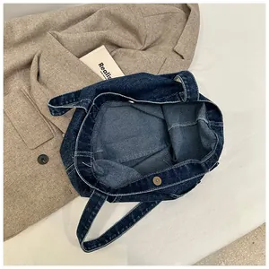 Detail view of the metal magnetic clasp and heavy denim fabric on this large tote bag