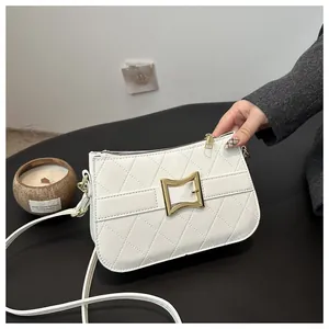 Détail du sac bandoulière en cuir blanc matelassé avec fermoir géométrique doré
